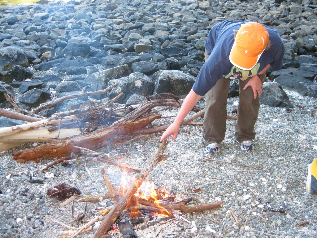 Woman stoking a campfire